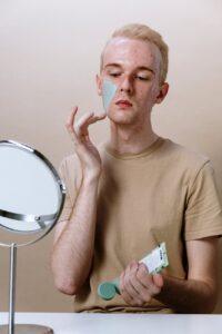 man applying facial mask for men